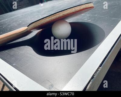 Tischtennis-Paddel und Ball auf einer Tischtennisplatte Stockfoto