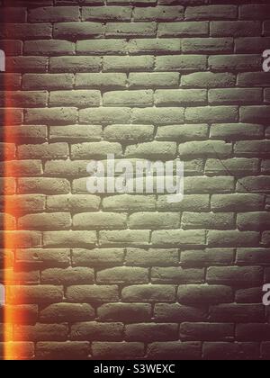 Ein Backsteinwand-Textur-Hintergrund mit Lichtreflexfilter und Grunge-Effekt Stockfoto