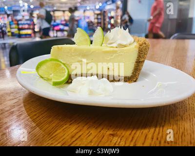 Ein Stück Keylim-Kuchen auf einem weißen Teller in einem Restaurant im Terminal D des Flughafens von Miami, Florida, USA Stockfoto
