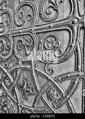 Ein monochromes Bild mit einigen Details der Great West Doors der Rochester Cathedral in Kent, England, Großbritannien. Diese denkmalgeschützte, dicke Holz- und Metalltür der Klasse 1 ist ein Kunstwerk. Foto ©️ COLIN HOSKINS. Stockfoto