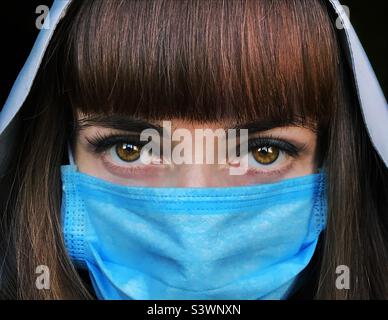Porträt einer jungen Frau in blauer medizinischer Maske Stockfoto