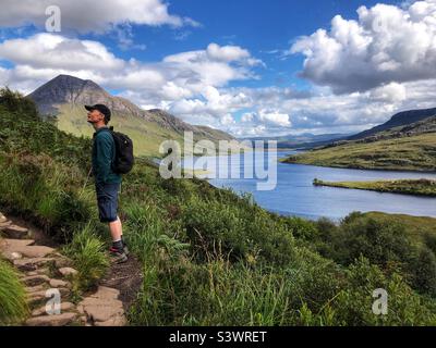 Walker auf dem Pfad nähern sich Stac Pollaidh oder Stack Polly, Berg in Inverpolly, mit Blick auf Loch Lurgainn, Nordwestschottland Stockfoto