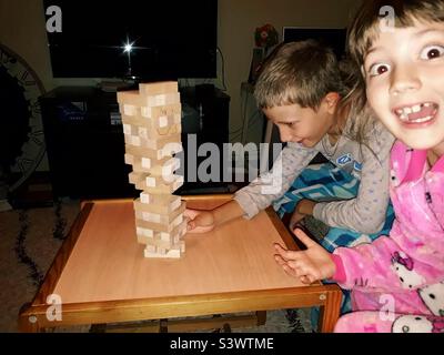 Kinder, die nachts zu Hause Jenga spielen Stockfoto