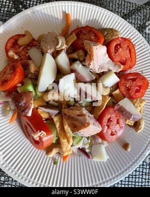 Ein gesunder Hauptgang-Salat aus gebratenen Lachsstückchen und neuen Kartoffeln über einem Kopfsalat mit Tomaten aus Erbstück, 2022, USA Stockfoto