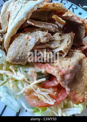 Döner Kebab in Pitta-Brot mit Salat und Chilisauce Stockfoto