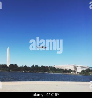 Hubschrauber Silhouette fliegen über Washington DC mit Monument und Natural History Museum im Hintergrund Stockfoto