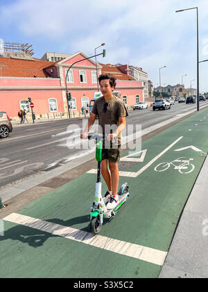 Junger Mann auf seinem Elektroroller in Lissabon, Portugal Stockfoto