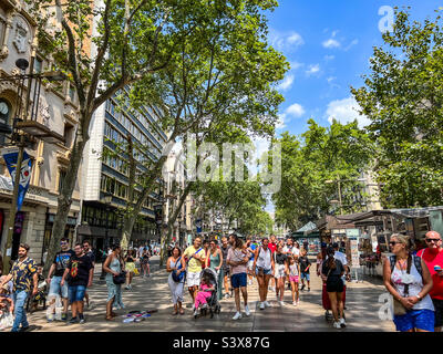 Touristen, die entlang der Rambla Straße in Barcelona Spanien spazieren Stockfoto