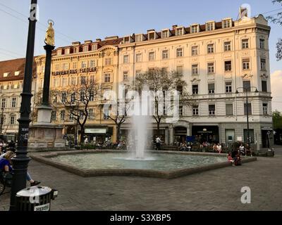 Brunnen am Eisernen Tor, mit Mariensäule (Mariensaeule) links und Klavierhaus Fiedler & Sohn dahinter, Graz, Österreich. Stockfoto