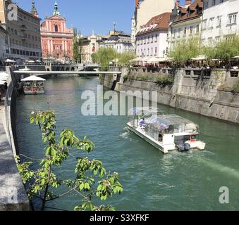 Touristenboot auf dem Fluss Ljubljanica, das durch die Altstadt von Ljubljana, Slowenien, fährt. Stockfoto