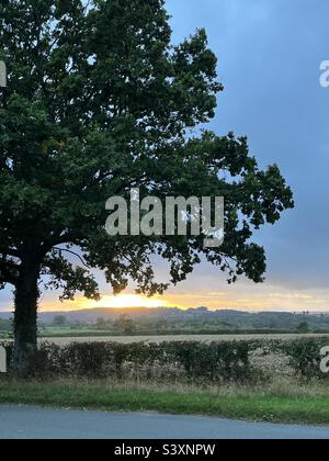 Sonnenuntergang über den Gloucestershire Feldern vor stürmischem Himmel Stockfoto