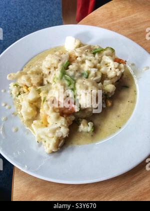 Ein Teller mit Essensresten, Blumenkohl, Reissuppe und Salat. Stockfoto