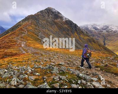 Weibliche Walkerin auf dem Weg und den Hängen von Munro Buachaille Etive Beag, Glencoe, Schottland Stockfoto