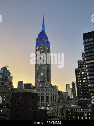 Blaue Turmleuchten am Empire State Building bei Abenddämmerung in New York City, USA Stockfoto