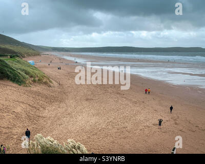 Einige Besucher genießen einen Herbstspaziergang am Woolacombe Beach Stockfoto