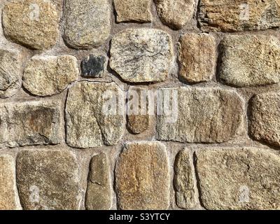 Steinwand mit Brauntönen als strukturierter Hintergrund Stockfoto