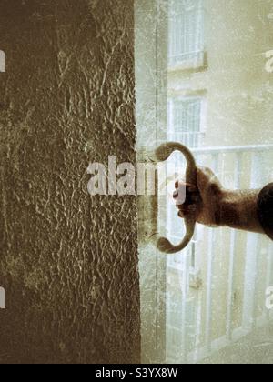 Eine Person, die die Schiebetür in Grunge-Effekten hält Stockfoto