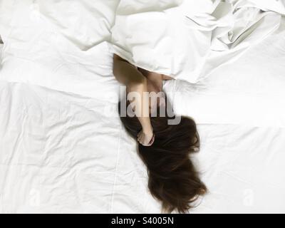 Junge schläfrige Frau im Bett Stockfoto