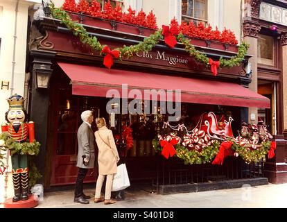 Leute, die in einem Restaurantfenster auf die Speisekarte schauen. Weihnachten 2022 in der Gegend von London Covent Garden Stockfoto