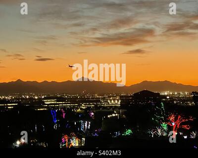 Blick vom Governor Hunt Tomb des Flugzeugs, das in den Phoenix Sky Harbor fliegt bei Sonnenuntergang mit Blick auf Papago Park, Phoenix Zoo Lights, Salt River, City Lights of Tempe / Phoenix Arizona, South Mountain Hintergrund Stockfoto