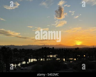 Blick vom nahe gelegenen Governor Hunt Tomb und Hole-in-the-Rock mit Blick auf Papago Park/Zoo Teiche bei Sonnenuntergang mit Wolken in sanftem blauem orangefarbenem Himmel, Sonnenuntergang unter South Mountain, Phoenix Arizona Stockfoto