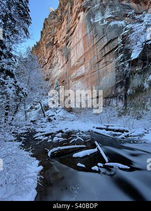 Winter Wunderland, Sedona Arizona, West Fork, Oak Creek Canyon, Frosted Tree Branches, Rote Felsen, grüne Kiefern, blauer Himmel, schneebedeckte Felsen und Baumstämme im eisigen, gefrorenen Bach Stockfoto