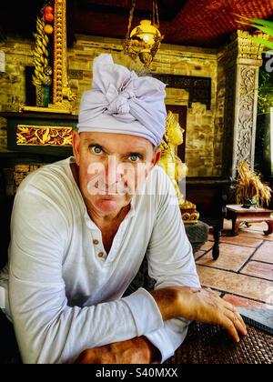 Westlicher Mann mit blauen Augen im traditionellen balinesischen Kopfkleid Udeng am Galungan-Tag Stockfoto