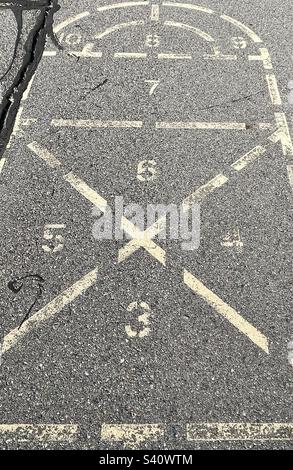 Erinnert an die Kindheit vor Jahrzehnten, bleibt dieser Hopscotch, dieser Platz auf dem Spielplatz, wie auch die Grundschule selbst. Stockfoto