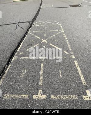 Erinnert an die Kindheit vor Jahrzehnten, bleibt dieser Hopscotch, dieser Platz auf dem Spielplatz, wie auch die Grundschule selbst. Stockfoto