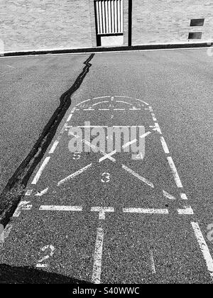 Erinnert an die Kindheit vor Jahrzehnten, bleibt dieser Hopscotch, dieser Platz auf dem Spielplatz, wie auch die Grundschule selbst. Stockfoto