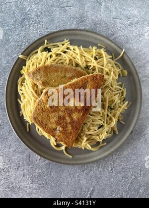 Panierte Thunfischsteaks mit Spaghetti aglio i olio Stockfoto