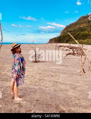 Wunderschöne Frau posiert zwischen verschiedenen Treibholzstücken am Strand von Lo De Marcos. Stockfoto