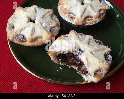 Zerkleinerte Kuchen auf einem dunkelgrünen Teller mit goldenem Rand, traditionelle Weihnachtsgeschenke, Abb. 12. Stockfoto