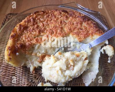 Kartoffelpüree garniert mit geriebenem Käse und im Ofen gebacken bis goldbraun. Servierlöffel mit cremefarbenem, weißem Püree darunter. Abb. 23 Stockfoto