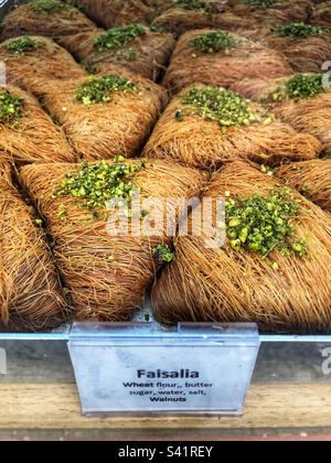 Faisalia oder Faisalia, ein dreieckiges Baklava mit einer Außenseite aus Fäden aus Kataifi-Teig und einer Füllung aus Pistazien oder Walnüssen, ein syrisches und nahöstliches Süßigkeiten in der Bäckerei Stockfoto