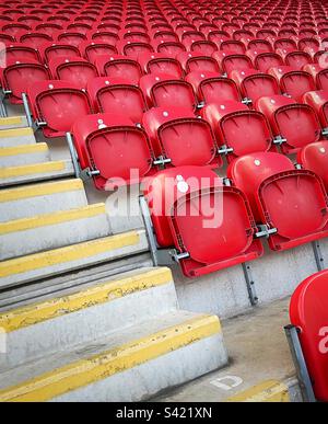 „Viel Platz“ mit leeren roten Sitzplätzen am Spieltag am Ende des Spiels. Stockfoto