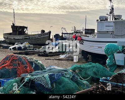Fischernetze und alte hölzerne Fischerboote am Hastings Beach in East Sussex, England Stockfoto