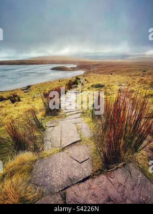 Der Fußweg nähert sich Llyn y Fan Fawr von Fan Brycheniog, Western Brecon Beacons (Bannau Brycheniog), Wales, Februar. Stockfoto