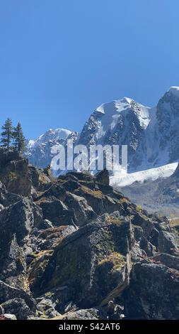 Drei Berggipfel mit Gletschern und Schnee an einer Steinklippe mit Bäumen im Altai in Sibirien. Stockfoto