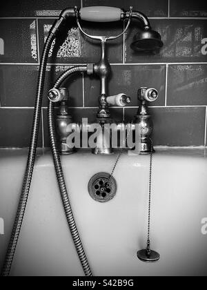 Bad im viktorianischen Stil mit Wasserhahn, Duschschlauch und Duschkopf in Schwarz und Weiß Stockfoto