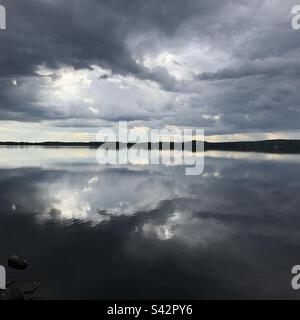 Grüblende dunkle Sturmwolken in einem großen See in der Kajaani-Region Finnlands während eines arktischen Sommers Stockfoto