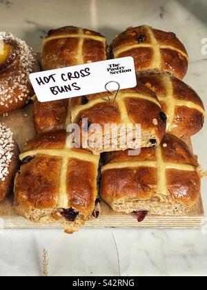 Hot Cross Brötchen im Fenster der Bäckerei Stockfoto