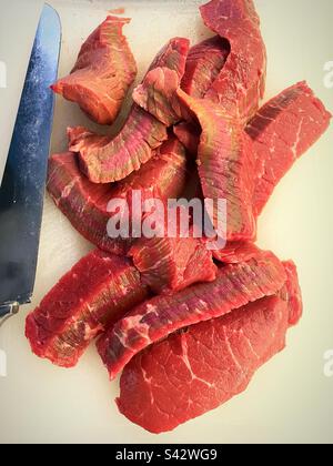 Ein in Scheiben geschnittener Londoner Braten auf einem Schneidebrett mit einem großen Messer, 2023, USA Stockfoto