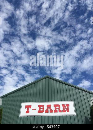 Die grüne Scheune (mit Metallverkleidung) auf der Durham Fair in Durham, Connecticut. Wunderschöner blauer Himmel mit flauschigen Wolken. Auf dem großen Schild mit roten Buchstaben steht: T-SCHEUNE Stockfoto