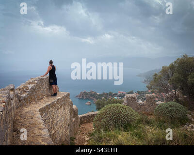Mann genießt die unglaubliche Aussicht von der Spitze der alten Steinmauern, Rocca di Cefalù, Sizilien. Stockfoto