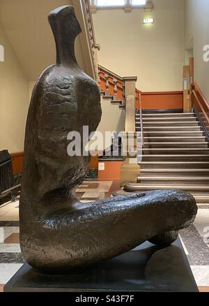 „Sitzende Frau: Thin Neck“ eine Statue aus dem Jahr 1961 in Bronze von Henry Moore (1898-1986), dem berühmten britischen Bildhauer. Das ist in der Laing Art Gallery in Newcastle Upon Tyne, Großbritannien. Stockfoto