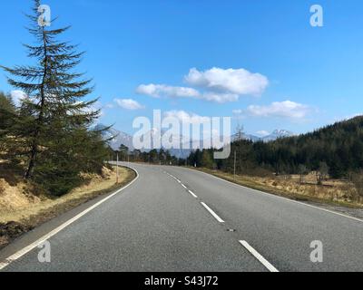 A85 km lange Straße im schottischen Hochland, schneebedeckte Gipfel und blauer Himmel, Blick auf Ben More und Stob Binnein bei Crianlarich Stockfoto