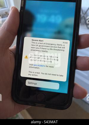 Mobiltelefon in der Hand mit Textnachricht. Schwere Alarmwarnung, ein Test der britischen Regierung, der am 23. April 2023 an Handys geschickt wurde. Stockfoto