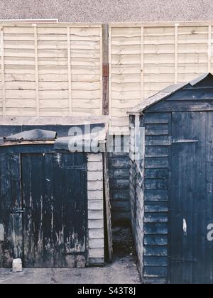 Zwei wackelige Schuppen, die repariert werden müssen, am Boden eines Gartens. Stockfoto