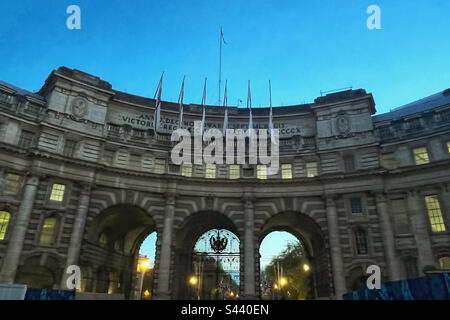 In Auftrag gegeben von König Edward VII. Zum Gedenken an Königin Victorias Tod, entworfen von Sir Aston Webb und fertiggestellt im Jahr 1912, Admiralty Arch in der Dämmerung bereitet sich auf die Krönung von König Karl III. Vor Stockfoto